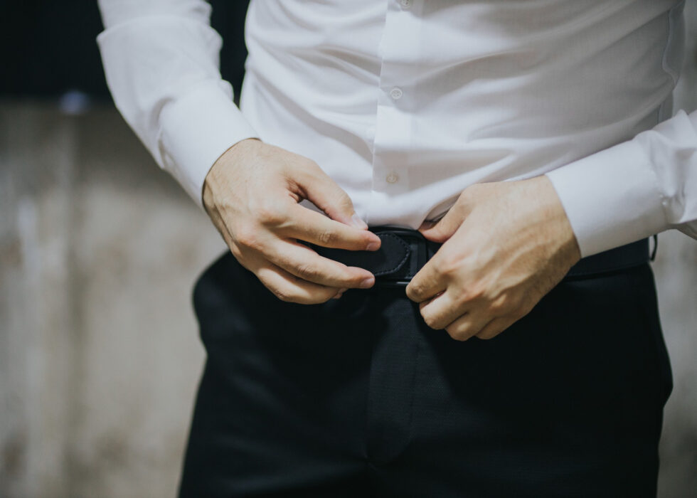 Closeup shot of a young and handsome groom getting dressed.