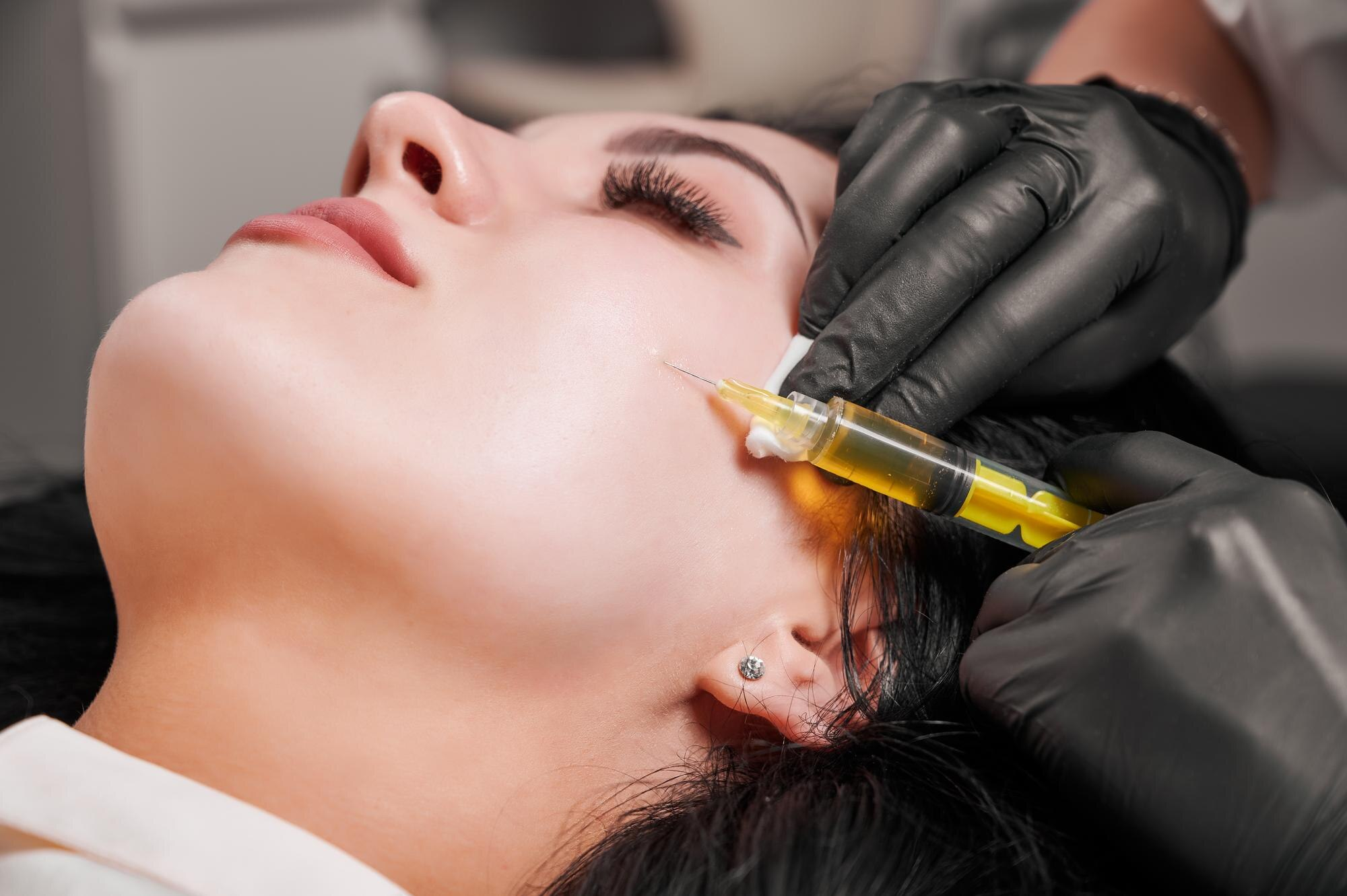 Female doctor making injection in woman chin